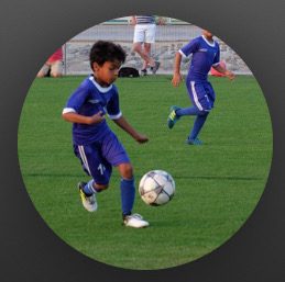 Dev as a young junior footballer dribbling the ball
